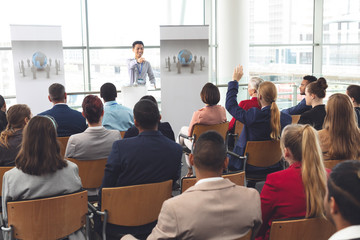 Obraz premium Businessman raising hand in a business seminar