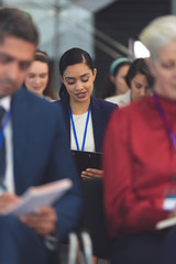 Young businesswoman writing on notepad in a business seminar