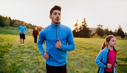 A large group of people cross country running in nature.