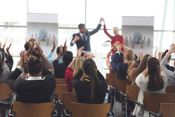 Business people applauding and celebrating in a business seminar