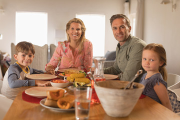 Happy family sitting on dining table at home