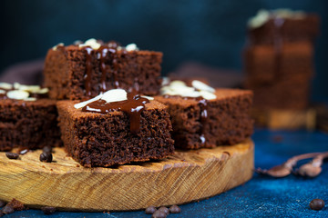 Traditional Belgian chocolate brownies decorated with warm chocolate lie on a wooden Board....