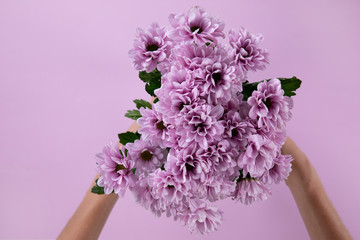 Woman holding a bouquet of pink flower between her hands 