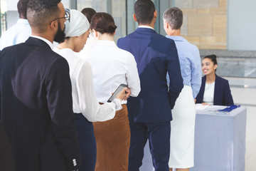 Business people checking in at conference registration table