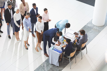 Business people checking in at conference registration table