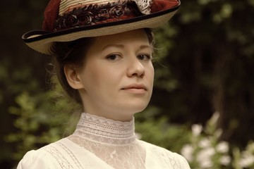 Portrait of a young woman in a beautiful hat and white blouse.