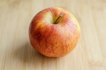 Fresh red apple on wooden table. Selective focus.