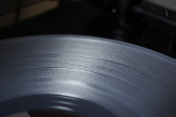 Grooves of clear white semi transparent vinyl record disc on black turntable