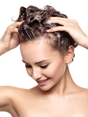 Beautiful smiling woman soaping the hair