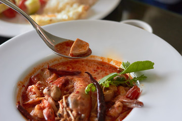 Tom yum kung or spicy prawn shrimp soup with scoop in spoon
