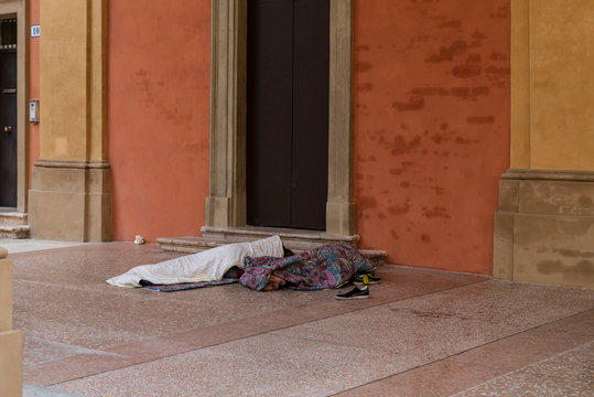 Poor homeless people or refugees sleeping on an urban street in the city, social documentary concept.