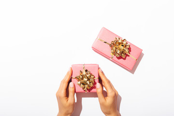 Gift boxes packed in pink paper with golden bows