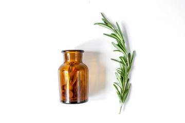 fresh rosemary with bottle on white background top view