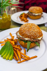 A hunberger with fried potatos and abocado, Mexico