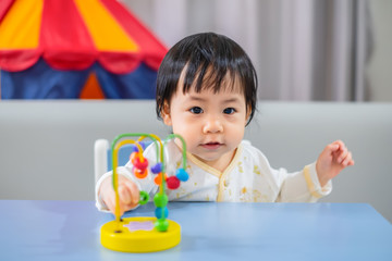 Asian baby girl playing toys at home