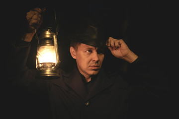 Detective agent with a kerosene lamp in the darkness.