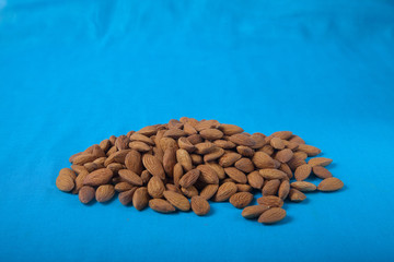 Almonds on a blue background. Copy spais.