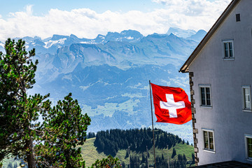 View on Switzerland flag. Hotel and mountains - Swiss Alps in the background