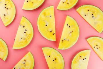 Juicy slices of yellow watermelon on a bright pink background. Conceptual colors of summer. Patterns top view as a background or substrate