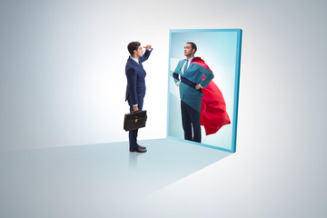 Fototapeta premium Businessman seeing himself in mirror as superhero