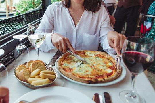 crop picture of woman in restaurant eating pizza drinking wine