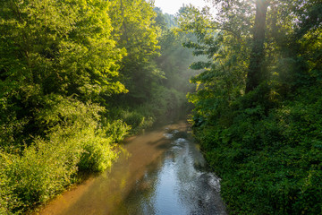 Il fiume Lente, il suo sottobosco e il paese di Sorano, Toscana, italia, alla luce dei primi raggi...