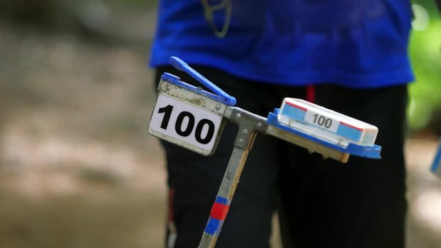 Blue black jersey sportsman is comming at check point inserts chip at control stations to record the fact that he was there and the time.