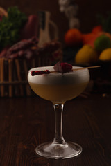 Beautiful cocktail in the chalet on a wooden background. Background decorated with fruits and herbs.