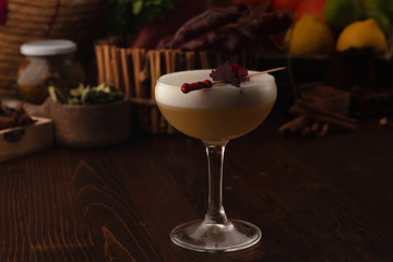 Beautiful cocktail in the chalet on a wooden background. Background decorated with fruits and herbs.