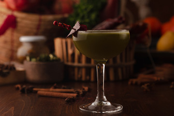 Beautiful cocktail in the chalet on a wooden background. Background decorated with fruits and herbs.