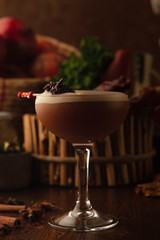Beautiful cocktail in the chalet on a wooden background. Background decorated with fruits and herbs.