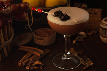 Beautiful cocktail in the chalet on a wooden background. Background decorated with fruits and herbs.