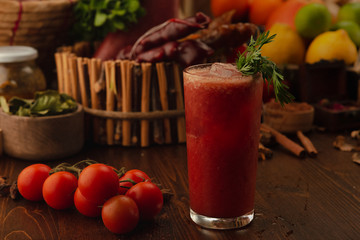 Cocktail Bloody Mary on a wooden background. Background decorated with fruits and herbs.