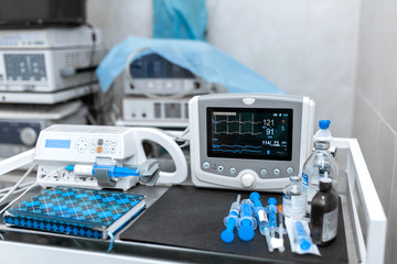 Cardiac monitor and syringe at operating table. Pet surgery