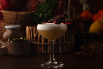 Beautiful cocktail in the chalet on a wooden background. Background decorated with fruits and herbs.