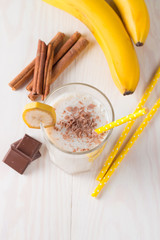 Fresh Made Chocolate Banana Smoothie on a wooden table. Selective focus. Milkshake with almonds. Protein diet. Healthy food and drink concept.