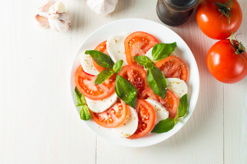 Close-up photo of caprese salad with ripe tomatoes, basil, buffalo mozzarella cheese. Italian and Mediterranean food concept. Fresh and healthy organic meal. Starter and antipasti.