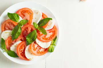 Close-up photo of caprese salad with ripe tomatoes, basil, buffalo mozzarella cheese. Italian and Mediterranean food concept. Fresh and healthy organic meal. Starter and antipasti.