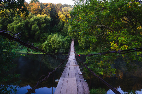 Fototapeta Suspension bridge over the river. Wooden suspension bridge in the summer in the village of Khotylevo, Bryansk