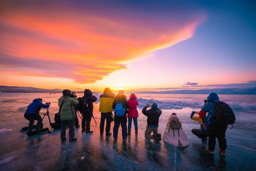 Photographers or Travellers using a professional DSLR camera take photo beautiful landscape of Baikal lake at sunset winter, Rusia - Recreation and outdoor travel concept. - obrazy, fototapety, plakaty