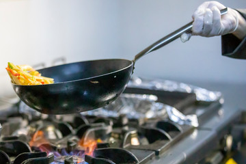 Chef is stirring vegetables in wok