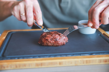 Businessman holding fork and knife eating steak, business and food.restaurant concept.eating stake from plate with fork and knife man hands.Man eating delicious juicy steak