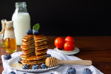 Blueberry Homemade pancake with sweet honey,milk and tomato on wood table .Horizontal photos