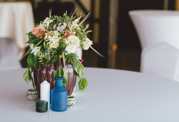 Bouquet of different flowers in a vase on table, preparing for event, wedding