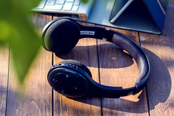 Headphones and laptop are on the table outdoor. Technology and lifestyle concept