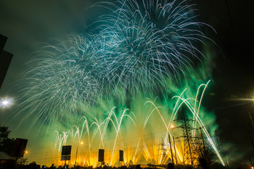 Blue, green and yellow festive fireworks on a black background. Abstract holiday background. International Fireworks Festival ROSTEC