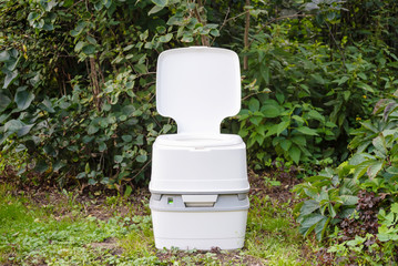 Chemical portable toilet. Single portable toilet standing on a green meadow