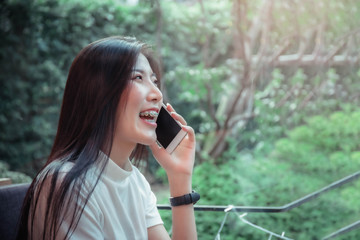 beatiful asian girl's holding mobile and have emotion happy looking at mobile phone