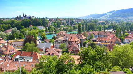 Fototapeta na wymiar View on Bern with the turquoise river Aare, the Dalmazibrucke and houses with characteristic red roofs, in summer 2019