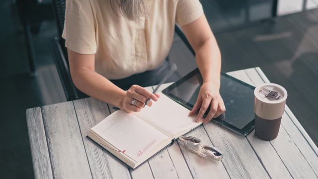 The Woman Is Tapping Her Notebook With A Pencil